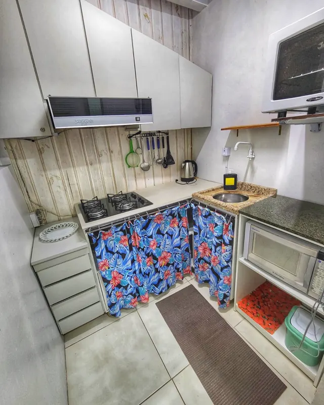 Cozinha com fogão, coifa e micro-ondas