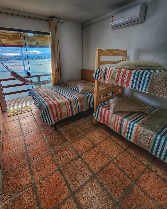 Quarto com cama e beliche, janela para o mar