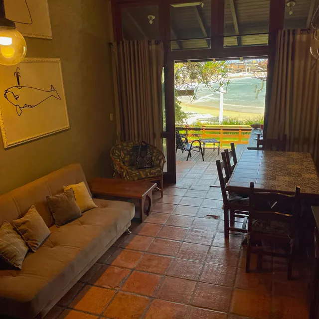 Sala com sofá aberta para o deck e o mar