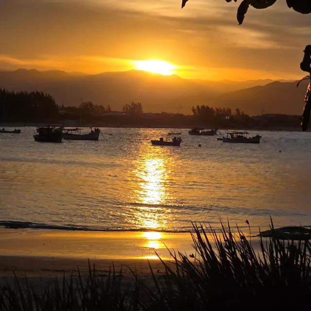 Sol se pondo atrás dos barcos na baía